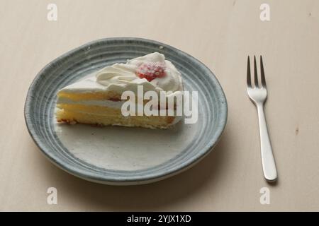 Shortcake e forchetta di fragole giapponesi su ogni piatto grande e piccolo su un tavolo di legno. Foto Stock
