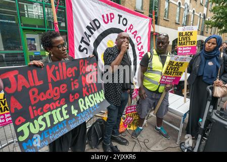 Londra, Regno Unito. 29 luglio 2017. Una donna tiene un manifesto del movimento per la giustizia alla protesta Stand Up to Racism alla stazione di polizia di Stoke Newington per Rashan Charles, morto quando due poliziotti lo ammanettarono e lo tennero sul pavimento in un negozio a Kingsland Rd nelle prime ore di sabato 22 luglio. La sua famiglia è determinata ad ottenere risposte sulla sua morte, ma chiede a tutti di agire secondo la legge. I membri della famiglia Charles sono venuti alla protesta insieme alla famiglia di Edson da Costa, che è morto dopo l'arresto a East Ham in giugno. I manifestanti tenevano le foto dei due uomini e di Darren Cumberbatch, che è morto Foto Stock