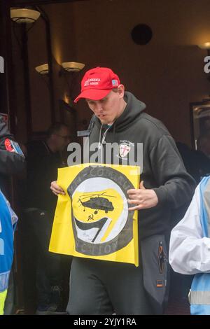 Londra, Regno Unito. 24 settembre 2017. Un uomo che indossa il cappello dei sostenitori di Trump e tiene in mano un poster "azione anticomunista" esce dal pub Wetherspoons di Whitehall. In seguito la polizia scortò circa 40 manifestanti a Charing Cross e lungo una strada secondaria fino all'Embankment, dove avrebbero dovuto tenere una manifestazione. In precedenza, la polizia aveva spostato diverse centinaia di contro-manifestanti antifascisti organizzati dall'UAF dal loro percorso verso un'area separata dell'Embankment a breve distanza, dove continuarono a protestare rumorosamente contro l'EDL fino a quando la polizia li scortò di nuovo alla stazione di Charing Cross. Sia EDL che Foto Stock