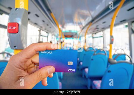 Carta Visa revolut in mano all'interno dell'abitacolo di un autobus a due piani, Londra. Regno Unito. Foto Stock