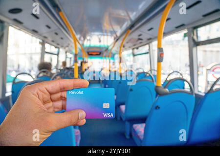 Carta Visa revolut in mano all'interno dell'abitacolo di un autobus a due piani, Londra. Regno Unito. Foto Stock