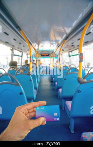 Carta Visa revolut in mano all'interno dell'abitacolo di un autobus a due piani, Londra. Regno Unito. Foto Stock