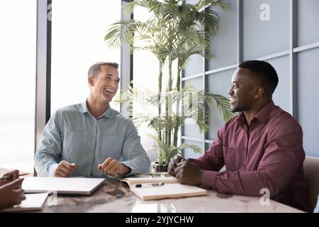 Due partner commerciali uomini diversi e positivi si incontrano per il lavoro di squadra Foto Stock