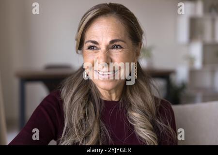Felice e premurosa signora anziana in pensione ispanica che posa per il ritratto Foto Stock