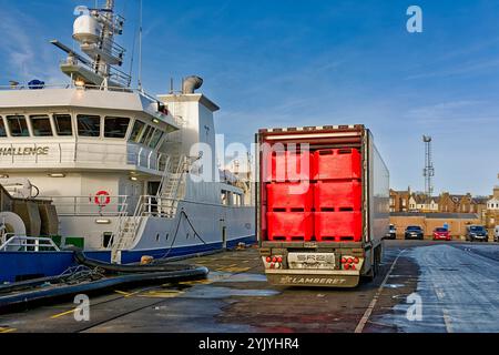 Peterhead Aberdeenshire Scozia il porto è una barca da pesca e un trasportatore carico di casse di pesci rossi Foto Stock