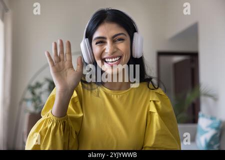 Allegra giovane influencer indiano ragazza in cuffie salutare il pubblico del blog Foto Stock