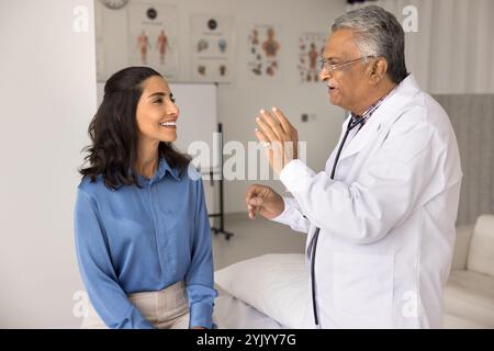 Il terapista sorridente fa raccomandazioni, spiega la diagnosi alla paziente Foto Stock