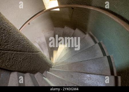 Scaletta a turbolenza, scalinata rotonda, scalini in pietra e ringhiera in legno, vista dall'alto verso il basso. Architettura degli interni Foto Stock