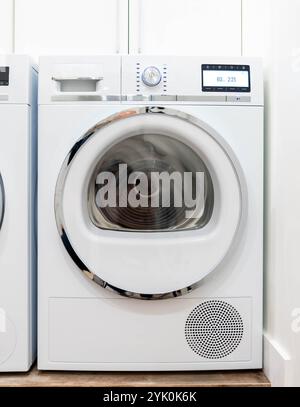 Una moderna lavatrice a caricamento frontale in una luminosa lavanderia, pronta per l'uso. Foto Stock