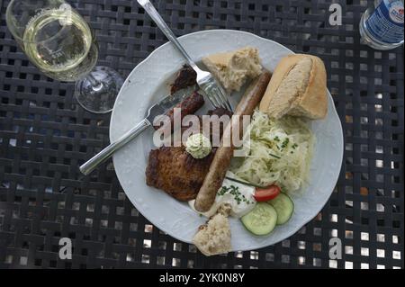 Bistecche e bratwurst con cavolo di cavolo e quark serviti in un pub con giardino, Baviera, Germania, Europa Foto Stock