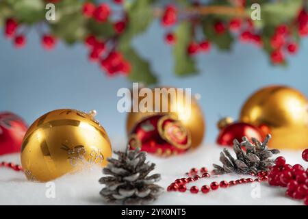 Decorazioni natalizie con baubles dorate e rosse sull'effetto neve Foto Stock