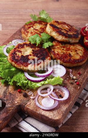 Cotolette di pollo fritte, pollo tritato, con verdure, su un tagliere, con insalata di verdure, vista dall'alto, fatti in casa, nessuno Foto Stock