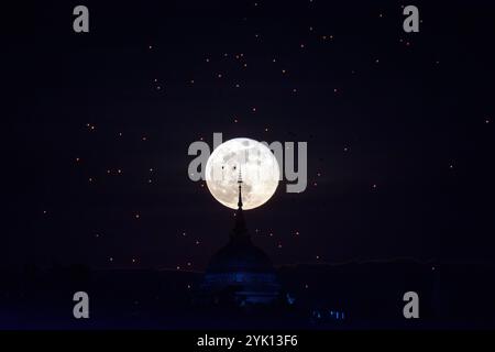 Chiang mai, Thailandia. 16 novembre 2024. La luna piena sorge dietro l'impronta del Buddha di Yonok City, accompagnata da lanterne galleggianti in stile Lanna nel giorno del Loy Krathong al Wat Phra That Doi Saket. (Credit Image: © Pongmanat Tasiri/SOPA Images via ZUMA Press Wire) SOLO PER USO EDITORIALE! Non per USO commerciale! Foto Stock