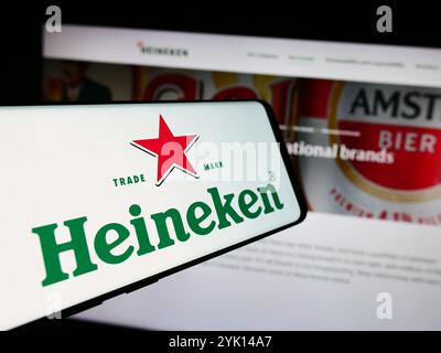 In questa immagine, un cellulare con il logo della società olandese Heineken N.V. è visibile davanti al sito Web aziendale. Foto Stock