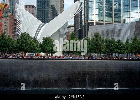 Questa immagine raffigura il 911 Memorial a New York City, con la fontana illuminata a cascata circondata da moderni grattacieli, Manhattan, New Yo Foto Stock