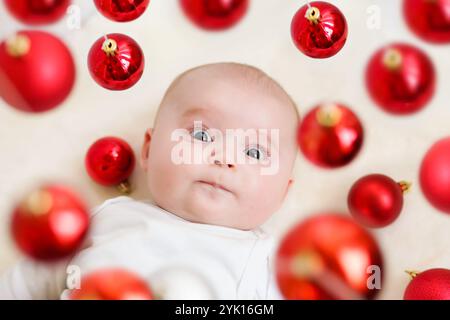 Ritratto di adorabile neonato. Ornamenti rossi di Natale. Buon Natale e felice anno nuovo Foto Stock