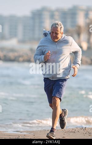 Uomo di mezza età che fa jogging all'aperto Foto Stock