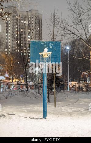Canestro da basket coperto di neve di notte Foto Stock