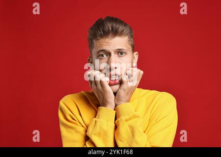 Studente emotivo che ha stress prima dell'esame su sfondo rosso Foto Stock