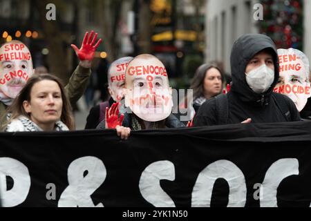 Londra, Regno Unito. 16 novembre 2024. Gli attivisti che indossano le maschere raffigurano politici con mani sanguinose fuori dall'ufficio londinese della compagnia petrolifera statale della Repubblica dell'Azerbaigian (SOCAR) come una coalizione di oltre sessanta gruppi per la campagna sul clima e i sostenitori della Palestina marciano attraverso il centro di Londra chiedendo al governo di porre fine alla nostra dipendenza dai combustibili fossili, pagando i finanziamenti per il clima e smettendo di sostenere la guerra di Israele a Gaza. L'Azerbaigian, che attualmente ospita i colloqui sul clima COP29, fornisce circa il 30% del petrolio di Israele attraverso la Turchia. Crediti: Ron Fassbender/Alamy Live News Foto Stock