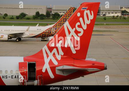 Bangkok, Thailandia - 29 giugno 2023: Un aereo della compagnia aerea low cost AirAsia è parcheggiato al cancello prima della partenza all'aeroporto Don Mueang. Foto Stock