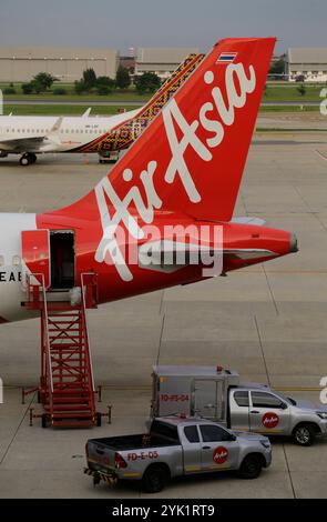 Bangkok, Thailandia - 29 giugno 2023: Un aereo della compagnia aerea low cost AirAsia è parcheggiato al cancello prima della partenza all'aeroporto Don Mueang. Foto Stock