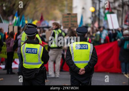 Londra, Regno Unito. 16 novembre 2024. Gli agenti di polizia vengono visti durante la dimostrazione. I manifestanti hanno marciato a Londra per chiedere che il governo britannico ponga fine alla dipendenza del Regno Unito dai combustibili fossili, paghi i finanziamenti per il clima e ponga fine alla sua complicità nell'escalation della violenza genocida di Israele. Credito: SOPA Images Limited/Alamy Live News Foto Stock
