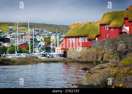 Tetti di prato edifici governativi a Tinganes e barche nel porto di Vestaravag a Torshavn, Isole Faroe Foto Stock