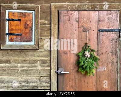 Porta della capanna in legno bavarese superiore con ramo di abete, inverno a Jachenau dicembre 201 Foto Stock