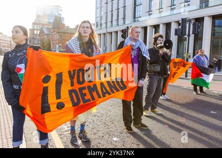 Leeds, Regno Unito. 16 NOVEMBRE 2024. Gli attivisti si trovano all'incrocio tra Clay PT Lane e Woodhouse Ln mentre la Youth Demand ha bloccato 2 strade nel centro di Leeds alla fine di una settimana di azioni pro Palestina in tutto il paese, dopo la seconda azione 3 degli attivisti sono stati effettivamente banditi dal centro della città in quanto sono stati emessi con ordini S34/S35 e scortati ai margini della città. Credito Milo Chandler/Alamy Live News Foto Stock