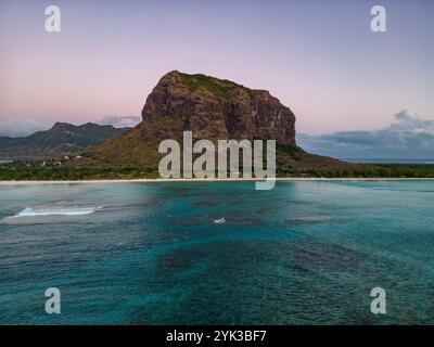 Vista aerea delle onde che si infrangono sulla barriera corallina al crepuscolo con la laguna e le Morne al crepuscolo, le Morne, Rivière Noire, Mauritius, Oceano Indiano Foto Stock