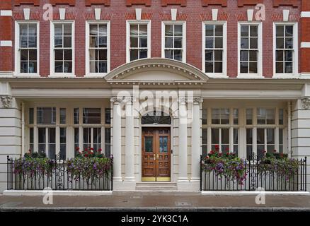 Londra, facciata di edifici per uffici professionali, con fiori su ringhiere Foto Stock