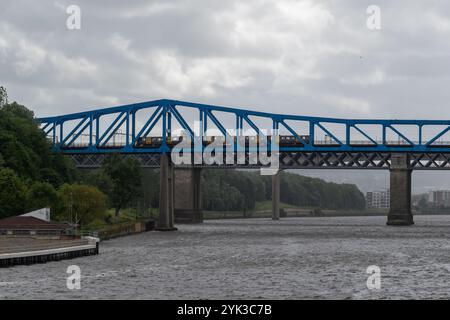 Newcastle, Regno Unito - 4 luglio 2024: Un treno Tyne and Wear della metropolitana che attraversa il ponte della regina Elisabetta II, con gli altri ponti del fiume Tyne alle spalle. Foto Stock