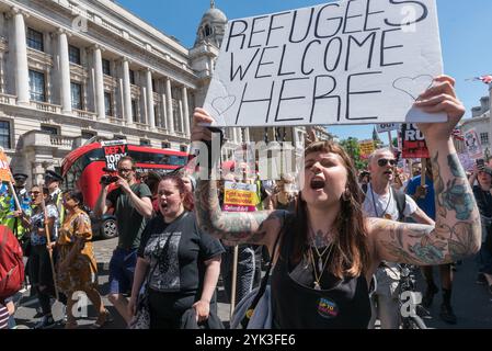 La folla che era venuta a Downing St per celebrare il multiculturalismo e l'antifascismo e per chiedere a Theresa May di non fare alcun patto con il DUP con i loro stretti legami con i terroristi paramilitari e il disprezzo per i diritti umani decide di andare in marcia, e salire su Whitehall verso Trafalgar Square, gridando slogan. All'inizio la polizia ha cercato di tenerli sul marciapiede, ma presto si è arresa. Foto Stock