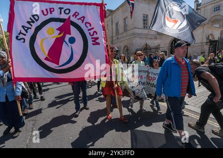 La folla che era venuta a Downing St per celebrare il multiculturalismo e l'antifascismo e per chiedere a Theresa May di non fare alcun patto con il DUP con i loro stretti legami con i terroristi paramilitari e il disprezzo per i diritti umani decide di andare in marcia, e salire su Whitehall verso Trafalgar Square, gridando slogan. All'inizio la polizia ha cercato di tenerli sul marciapiede, ma presto si è arresa. Foto Stock