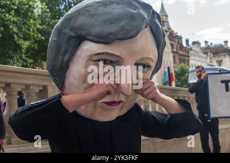 Londra, Regno Unito. 9 giugno 2017. Dopo che i risultati delle elezioni mostrarono che nessun partito aveva la maggioranza, i manifestanti giunsero a Westminster per chiedere che Theresa May si dimettesse. Ha intenzione di rimanere e cercare di governare, basandosi sui voti del partito estremista protestante dell'Ulster DUP, collegato ai paramilitari lealisti. Avaaz portò una persona con una grande testa caricaturale di Theresa May a Downing St per posare di fronte a uno striscione "il popolo ha parlato" e giaceva rose bianche davanti a una lapide con il messaggio "Hard Brexist R.I.P 2016-2017". Foto Stock