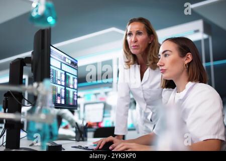 Scienziata donna che fa ricerca medica sullo schermo del computer Foto Stock