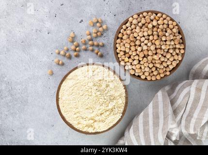 Farina di ceci e ceci in ciotole di legno su sfondo grigio. Farina alternativa senza glutine. Vista dall'alto. Foto Stock