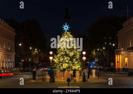 LONDRA - 15 NOVEMBRE 2024: Il bellissimo albero di Natale a Waterloo Place di fronte al Sofitel Hotel St James's è decorato in rosso e oro Foto Stock