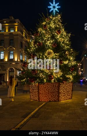 LONDRA - 15 NOVEMBRE 2024: Il bellissimo albero di Natale a Waterloo Place di fronte al Sofitel Hotel St James's è decorato in rosso e oro Foto Stock