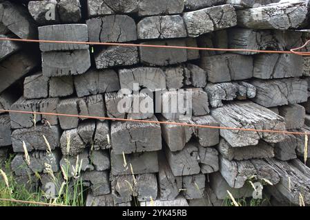 Vecchie traversine ferroviarie impilate in un mucchio Foto Stock