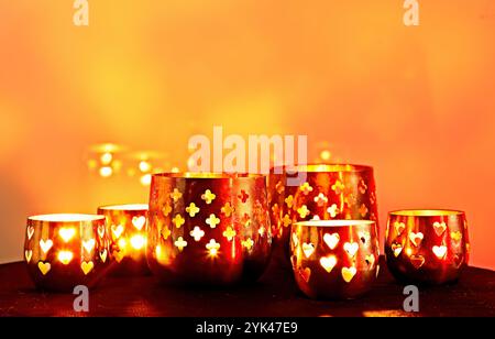 Candele in piccoli portacandele al buio che bruciano brillantemente Foto Stock