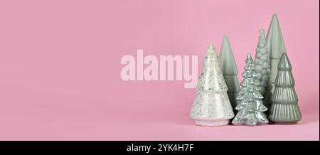 Alberi di Natale in ceramica verde chiaro di diversa forma su sfondo rosa Foto Stock