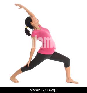 Esercizio asiatico di yoga incinta. Lezione di yoga prenatale. Donna incinta asiatica sana a tutta lunghezza che fa esercizio di yoga che si estende a casa, corpo intero isolato Foto Stock