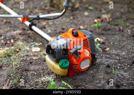 Il rasaerba si trova a terra. Preparazione del rifinitore per il lavoro. Foto Stock