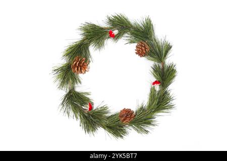 Semplice corona di Natale con coni di pino e piccoli funghi rossi Foto Stock