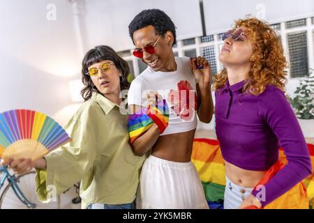 Studenti LGBT multietnici e di genere che festeggiano a casa festeggiando l'orgoglio Foto Stock