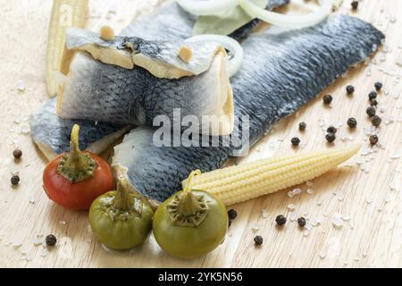 Acqua salata di pesce marinato, antipasto freddo. Aringhe marinate filetto sul tagliere di legno Foto Stock