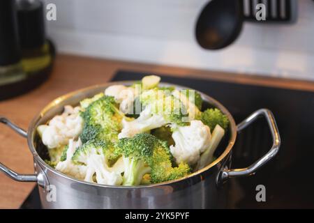 Broccoli e cavolfiore vengono cotti al vapore in una pentola, dieta sana, alimenti per bambini, cottura in una vaporiera Foto Stock