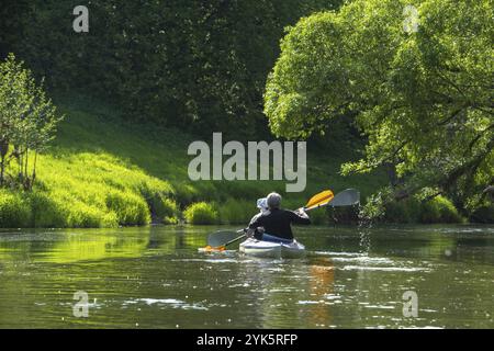 Gita in kayak per tutta la famiglia per il Seigneur e senora. Una coppia di anziani sposati che voga una barca sul fiume, un'escursione in acqua, un'avventura estiva. Sport legati all'età Foto Stock